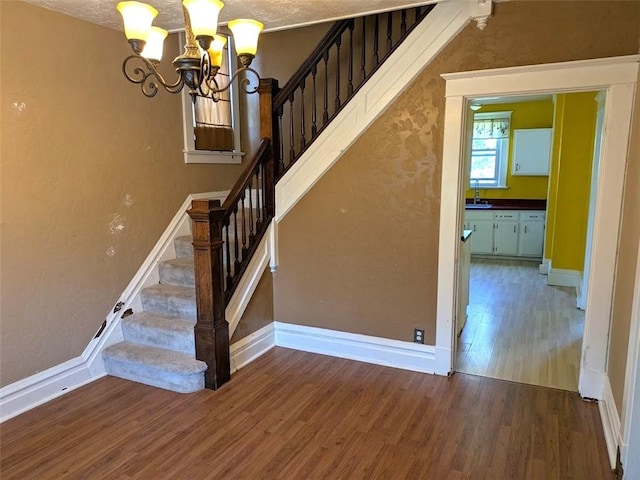 413 N 3rd St, Jeannette, PA 15644 - stairs featuring wood finished floors and a chandelier