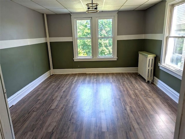 413 N 3rd St, Jeannette, PA 15644 - spare room featuring radiator heating unit, a paneled ceiling, plenty of natural light, and dark wood-style floors