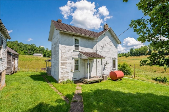481 Dille Run Rd, Morris Twp, PA 15329 - rear view of house featuring a standing seam roof, a chimney, a metal roof, heating fuel, and a yard