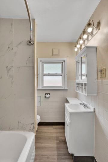 1850 Middle St, Sharpsburg, PA 15215 - bathroom with tile walls, vanity, wood finished floors, and wainscoting