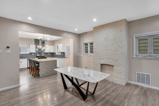 1850 Middle St, Sharpsburg, PA 15215 - dining space featuring a chandelier, wood finished floors, a fireplace, and recessed lighting