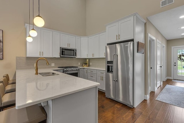 113 Dano Dr Unit 37, Ohioville, PA 15009 - kitchen with premium appliances, a peninsula, a high ceiling, decorative backsplash, and light stone countertops