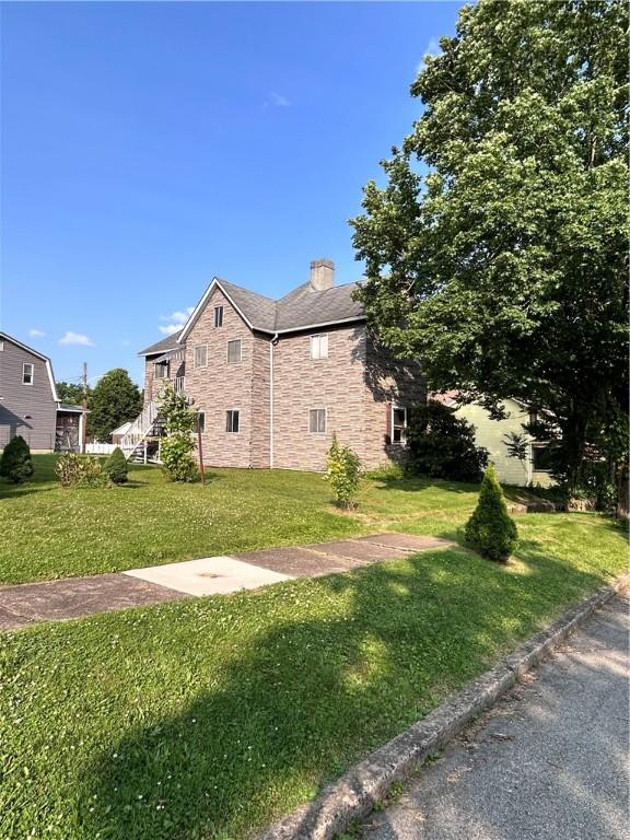 431 Washington Ave, Leechburg Boro, PA 15656 - view of property exterior with a lawn, a chimney, and stone siding