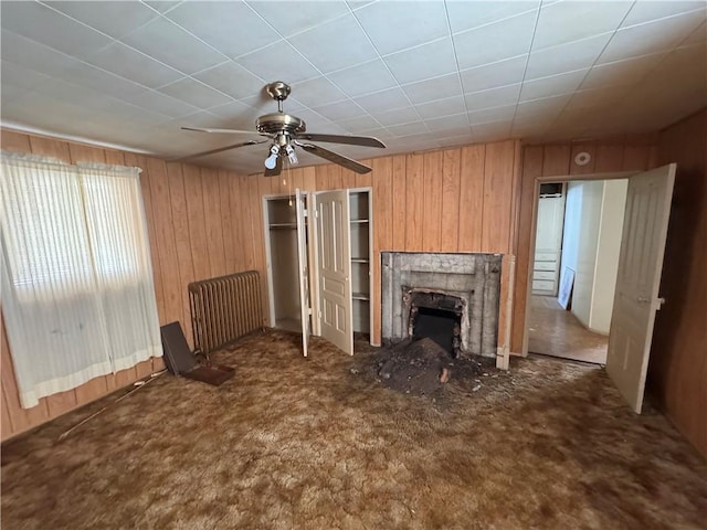 431 Washington Ave, Leechburg Boro, PA 15656 - unfurnished living room with wood walls, ceiling fan, carpet, and a fireplace