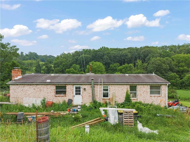 465 Sugar Run Rd, Nottingham, PA 15330 - rear view of house with a wooded view, a chimney, and brick siding