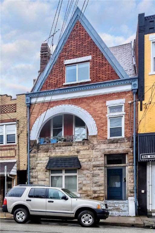 118 S 17th St, South Side, PA 15203 - view of front of property featuring stone siding, brick siding, and a chimney