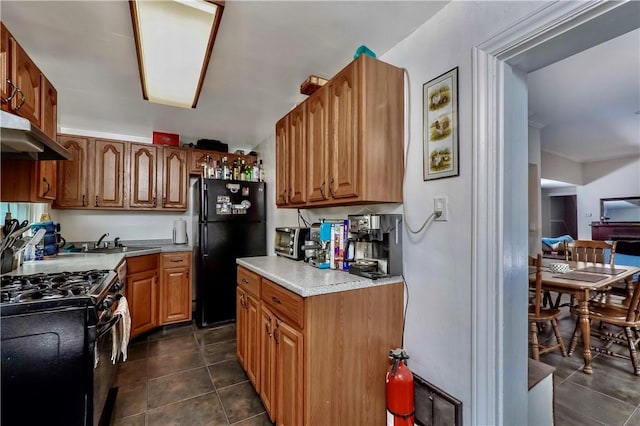118 S 17th St, South Side, PA 15203 - kitchen featuring black appliances, under cabinet range hood, dark tile patterned floors, light countertops, and brown cabinetry