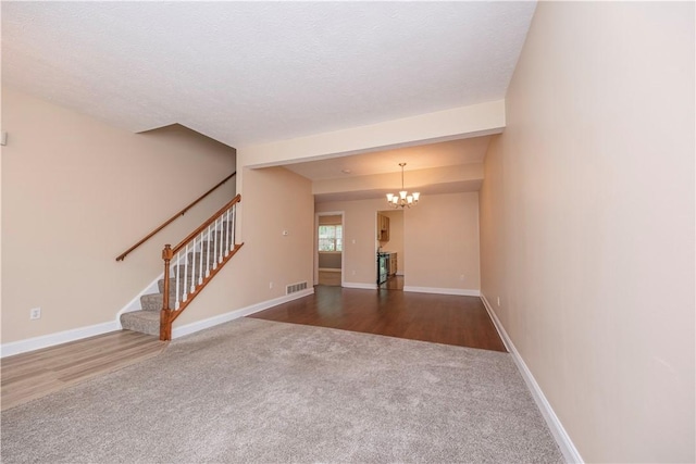 108 Arthur Ct, Richland, PA 15044 - unfurnished living room with carpet, a chandelier, stairway, and wood finished floors