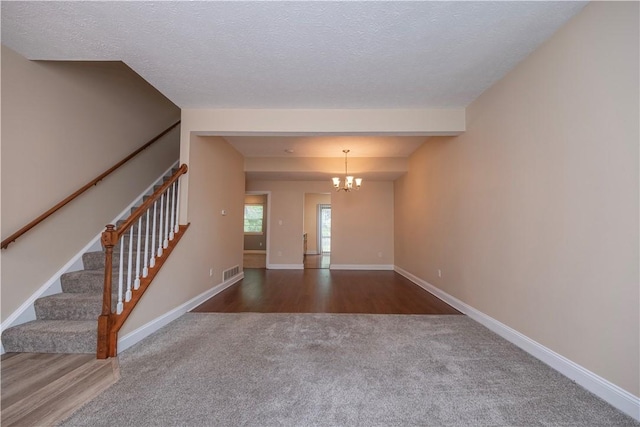 108 Arthur Ct, Richland, PA 15044 - unfurnished living room with carpet flooring, a chandelier, stairway, and a textured ceiling