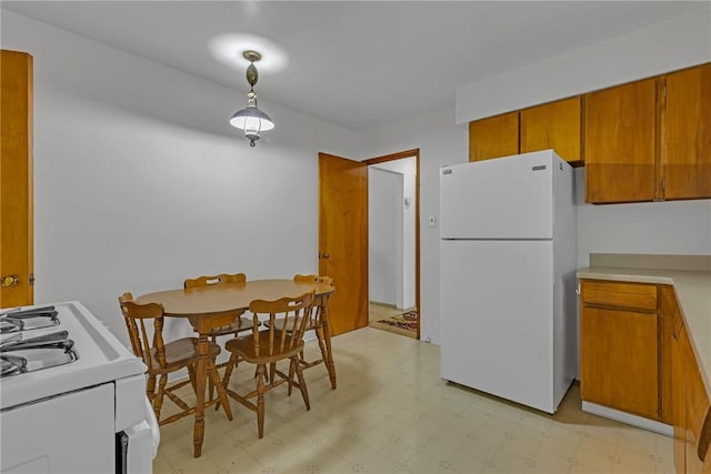 320 Wilson Ave, Beaver, PA 15009 - kitchen featuring white appliances, light flooring, brown cabinets, light countertops, and decorative light fixtures