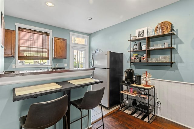 175-177 43rd 1/2 St, Lawrenceville, PA 15201 - kitchen featuring freestanding refrigerator, brown cabinetry, wood finished floors, wainscoting, and recessed lighting