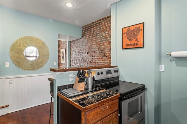 175-177 43rd 1/2 St, Lawrenceville, PA 15201 - kitchen with electric stove, tile counters, dark wood finished floors, a wainscoted wall, and brick wall