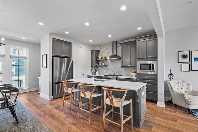 3155 Preston Way, Bridgeville, PA 15017 - kitchen with appliances with stainless steel finishes, wall chimney range hood, tasteful backsplash, an island with sink, and a breakfast bar area