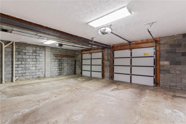 358 Shannon Cir, Daugherty Twp, PA 15066 - garage featuring a garage door opener and concrete block wall