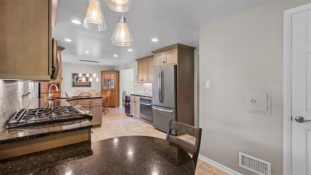 77 Ridgecrest Dr, Wilkins Twp, PA 15235 - kitchen featuring appliances with stainless steel finishes, decorative backsplash, recessed lighting, hanging light fixtures, and a peninsula