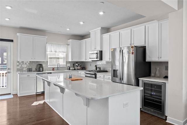 519 Captain Lee Boss Way, Cranberry Twp, PA 16066 - kitchen featuring stainless steel appliances, beverage cooler, a kitchen island, dark wood-type flooring, and white cabinetry