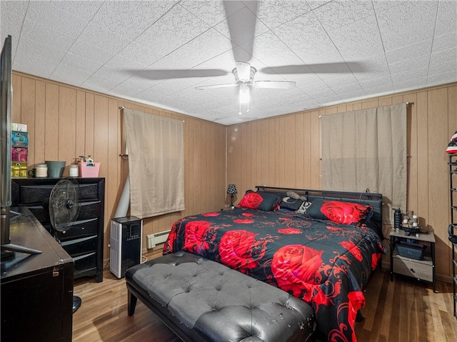 318 Penn Ave, Aliquippa, PA 15001 - bedroom with wood finished floors, a baseboard heating unit, wooden walls, and a ceiling fan