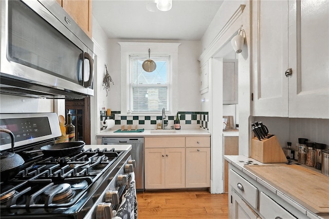 3100 Wainbell Ave, Dormont, PA 15216 - kitchen featuring appliances with stainless steel finishes, light wood-style floors, light countertops, and backsplash