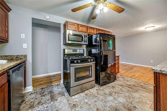 125 Holstein Dr, North Fayette, PA 15071 - kitchen with stainless steel appliances, brown cabinets, a ceiling fan, and light stone counters
