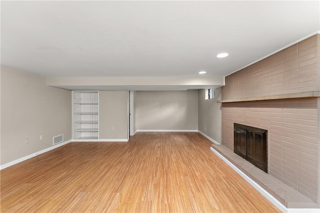 900 Tottenham Dr, Coraopolis, PA 15108 - unfurnished living room with a brick fireplace, light wood-style flooring, and recessed lighting