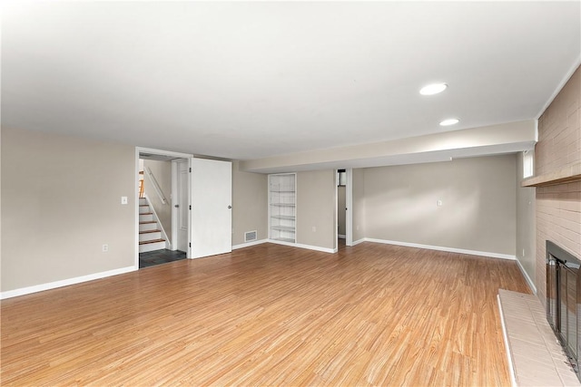 900 Tottenham Dr, Coraopolis, PA 15108 - unfurnished living room featuring a brick fireplace, stairway, light wood-style floors, and recessed lighting