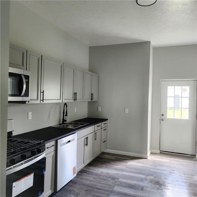 1914 Arlington Ave, Arlington, PA 15210 - kitchen with stainless steel appliances, wood finished floors, dark countertops, and a textured ceiling