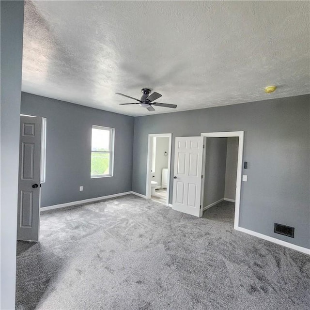 1914 Arlington Ave, Arlington, PA 15210 - unfurnished bedroom featuring a textured ceiling, carpet flooring, a ceiling fan, connected bathroom, and a spacious closet
