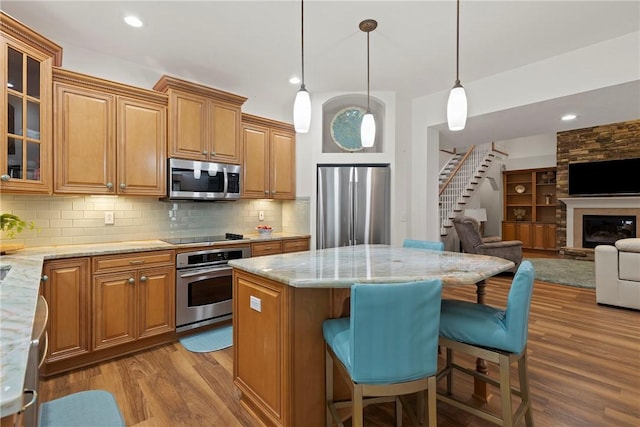 202 Providence Ct, Adams Twp, PA 16059 - kitchen with stainless steel appliances, wood finished floors, light stone countertops, a center island, and open floor plan