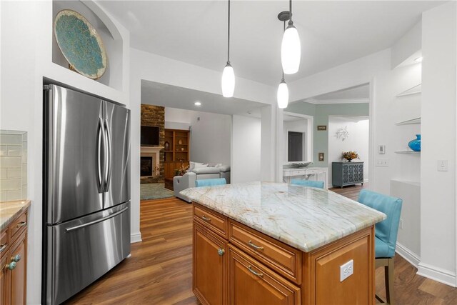 202 Providence Ct, Adams Twp, PA 16059 - kitchen featuring freestanding refrigerator, brown cabinets, open floor plan, dark wood-style floors, and a fireplace