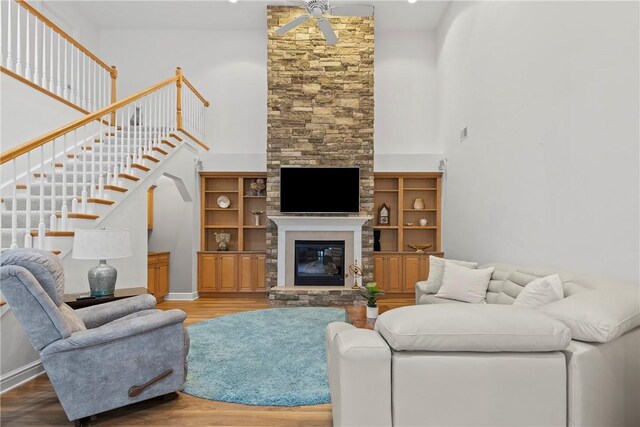 202 Providence Ct, Adams Twp, PA 16059 - living room featuring ceiling fan, wood finished floors, a high ceiling, a stone fireplace, and stairway