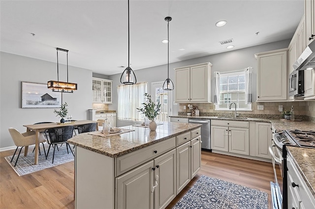 1009 Grey Fox Cir, Bridgeville, PA 15017 - kitchen with appliances with stainless steel finishes, a center island, backsplash, light wood-type flooring, and recessed lighting