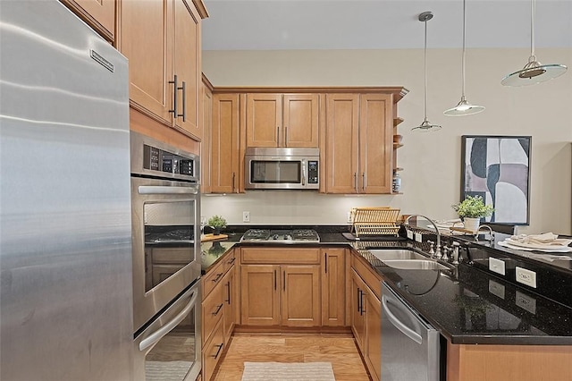 301 5th Unit 505, Downtown Pgh, PA 15222 - kitchen featuring appliances with stainless steel finishes, a peninsula, dark stone countertops, light wood finished floors, and hanging light fixtures
