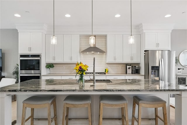 349 Azalea, Peters Twp, PA 15367 - kitchen with wall chimney exhaust hood, stainless steel appliances, tasteful backsplash, a kitchen island with sink, and recessed lighting