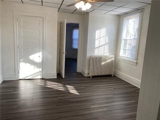 318 Mueller Ave, Crafton, PA 15205 - empty room with radiator heating unit, a paneled ceiling, ceiling fan, and dark wood-style flooring