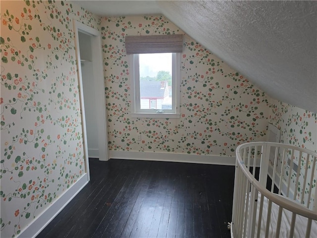 5303 Wickliff St, Lawrenceville, PA 15201 - unfurnished bedroom with wallpapered walls, lofted ceiling, hardwood / wood-style floors, a textured ceiling, and a nursery area