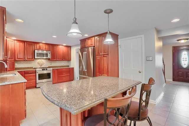 329 Oak Grove Ct, Mccandless, PA 15090 - kitchen featuring appliances with stainless steel finishes, light tile patterned floors, recessed lighting, a breakfast bar area, and light stone counters