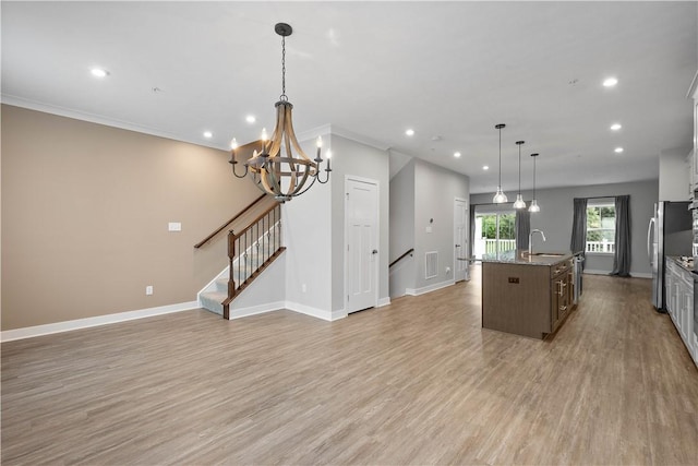 152 Cole Dr, Robinson Twp, PA 15136 - kitchen with recessed lighting, an island with sink, light wood-style flooring, open floor plan, and ornamental molding