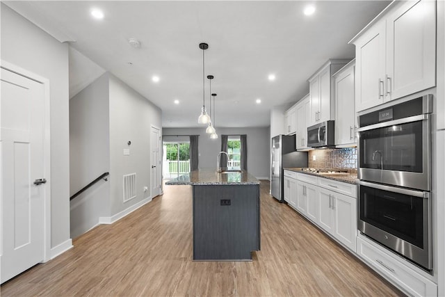 152 Cole Dr, Robinson Twp, PA 15136 - kitchen with appliances with stainless steel finishes, an island with sink, tasteful backsplash, recessed lighting, and light wood finished floors