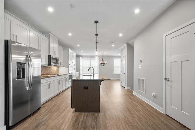 152 Cole Dr, Robinson Twp, PA 15136 - kitchen with appliances with stainless steel finishes, an island with sink, recessed lighting, wood finished floors, and backsplash