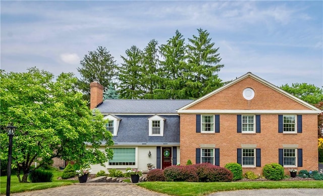 1061 Apple Hill Ln, Mccandless, PA 15101 - view of front facade featuring a chimney, a shingled roof, brick siding, and a front yard