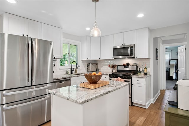 68 Cynthia Dr, Carnegie, PA 15106 - kitchen featuring appliances with stainless steel finishes, light wood-style floors, decorative backsplash, a center island, and recessed lighting