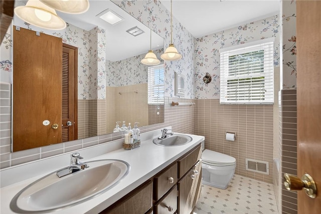 566 Ridgeview Rd, East Huntingdon, PA 15666 - full bath with wallpapered walls, double vanity, wainscoting, and tile walls