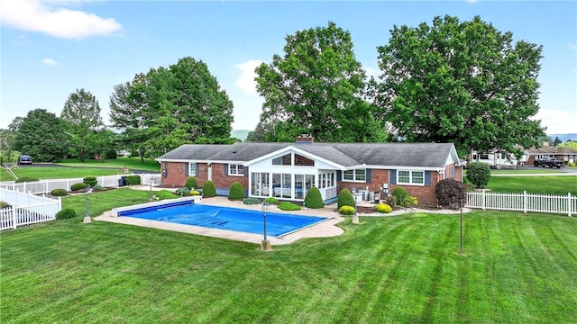 566 Ridgeview Rd, East Huntingdon, PA 15666 - rear view of house with brick siding, a fenced backyard, a chimney, and a sunroom