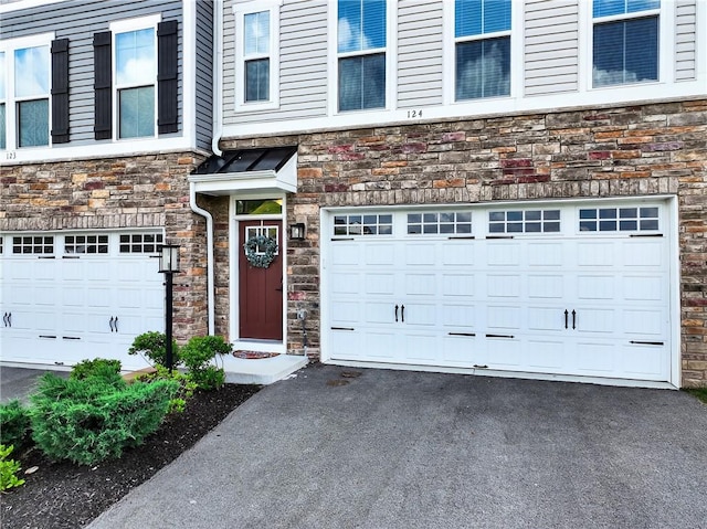 124 Rivulet Pl, Jackson Twp, PA 16063 - view of exterior entry featuring stone siding, a garage, and driveway