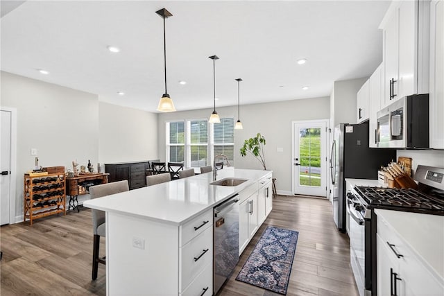 124 Rivulet Pl, Jackson Twp, PA 16063 - kitchen with stainless steel appliances, a breakfast bar area, an island with sink, dark wood-style flooring, and healthy amount of natural light