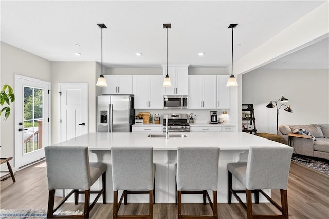 124 Rivulet Pl, Jackson Twp, PA 16063 - kitchen featuring appliances with stainless steel finishes, a breakfast bar area, a center island with sink, white cabinetry, and recessed lighting