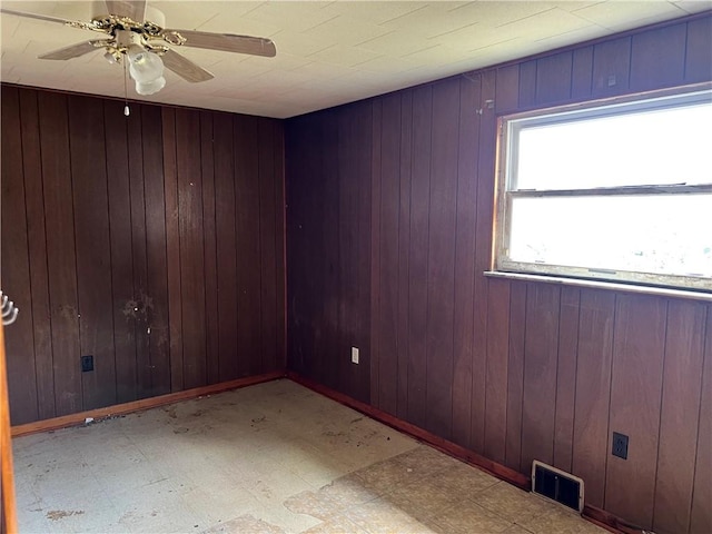 212 Shaffer Ave, Elizabeth Twp/Boro, PA 15037 - empty room with tile patterned floors, a ceiling fan, and wood walls
