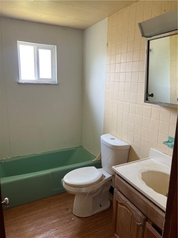 212 Shaffer Ave, Elizabeth Twp/Boro, PA 15037 - bathroom featuring tile walls, wood finished floors, vanity, and washtub / shower combination