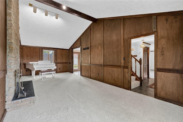 102 Barnwood Ln, Ross Twp, PA 15237 - corridor featuring wooden walls, a textured ceiling, stairway, carpet flooring, and rail lighting