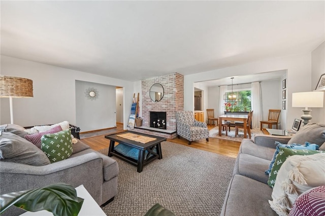12 Lynmar Dr, Shaler, PA 15209 - living area featuring wood finished floors, a brick fireplace, and a chandelier